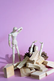 a wooden toy standing next to a pile of wood