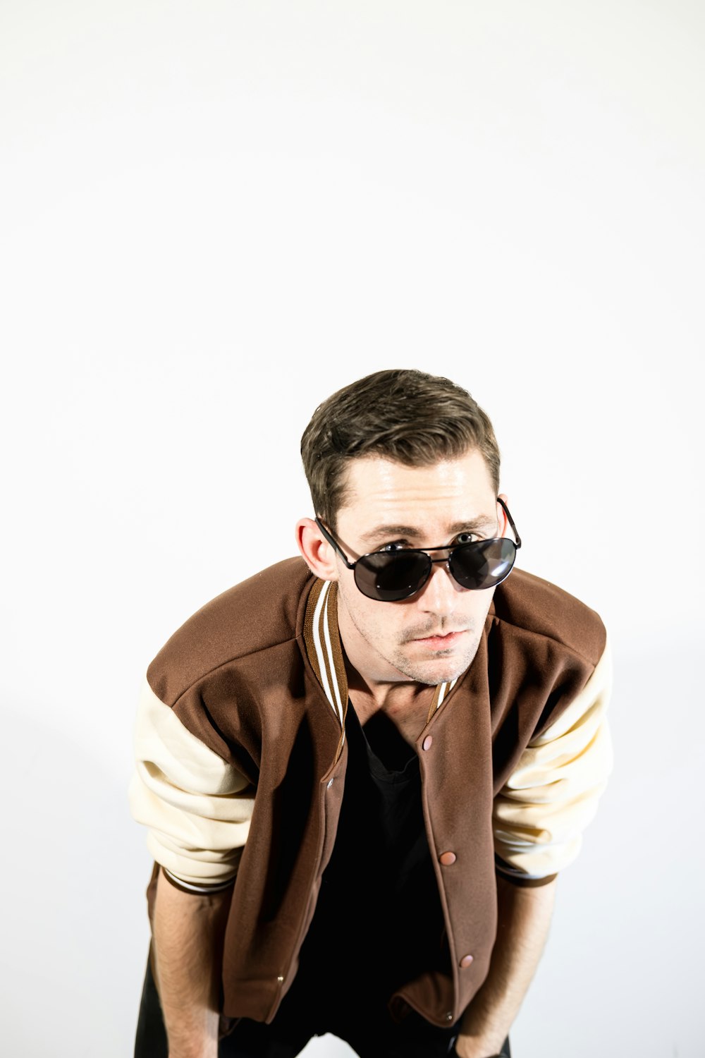 a man in a jacket and sunglasses posing for a picture