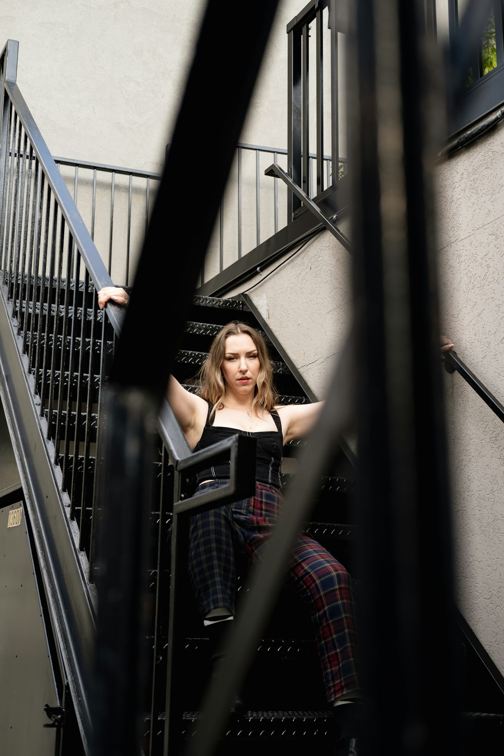 a woman is sitting on the stairs of a building