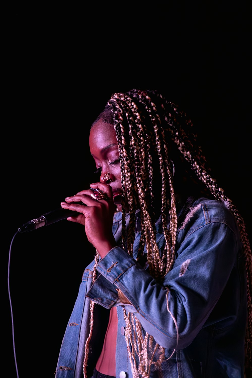 a woman with dreadlocks singing into a microphone