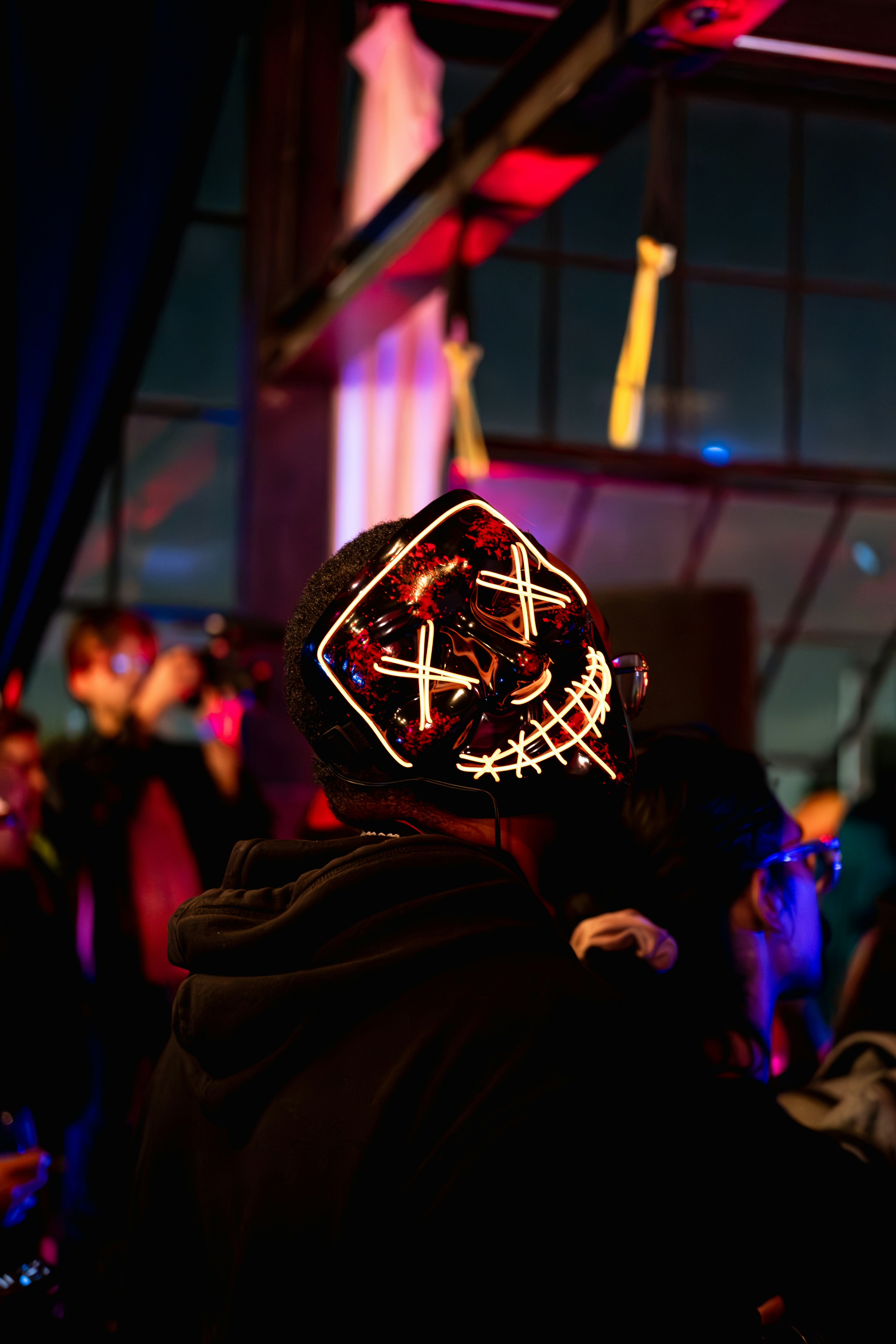 Festival attendee wearing Beatnix Costume Shop LED masks in a dark crowd