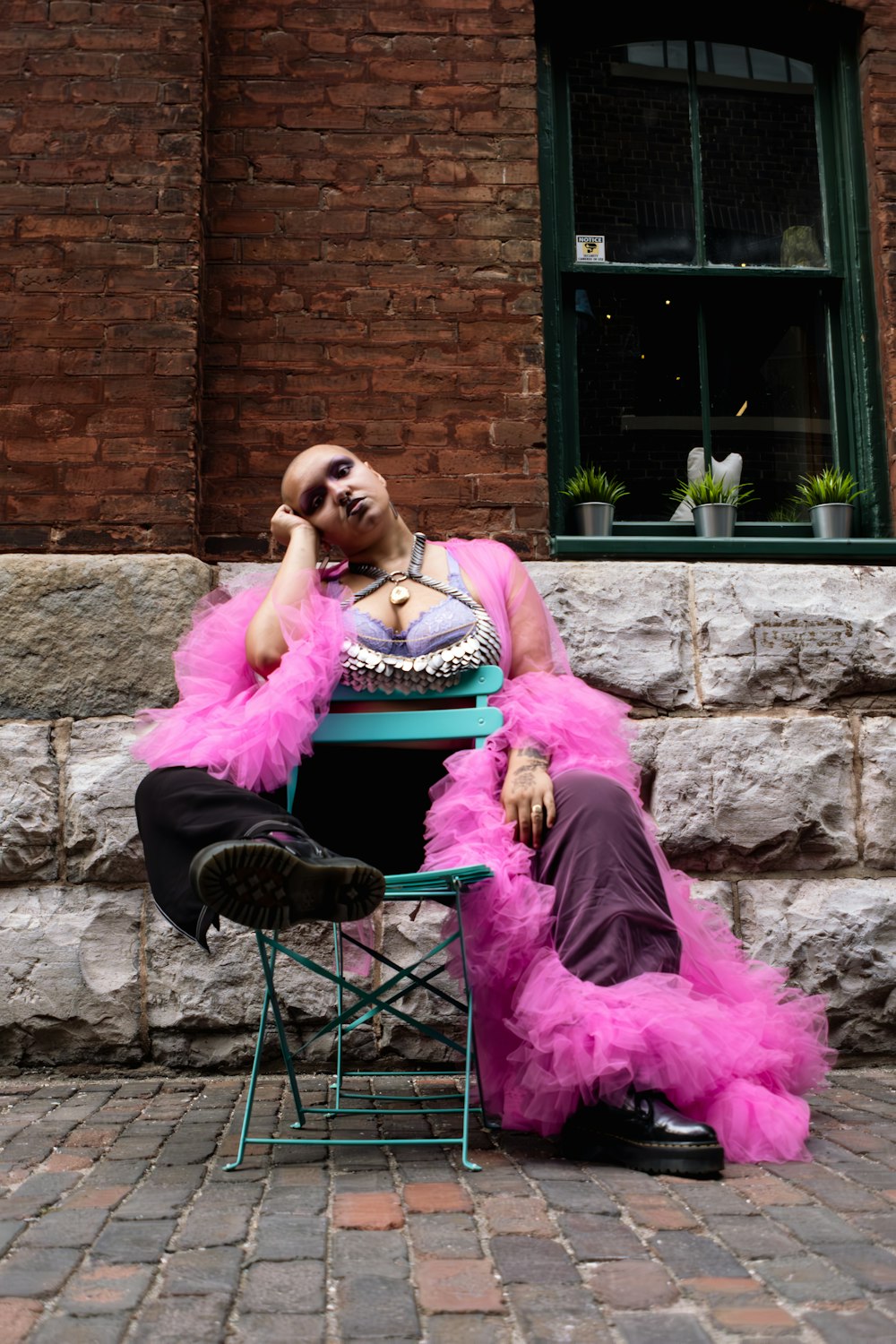 a man in a pink outfit sitting on a chair