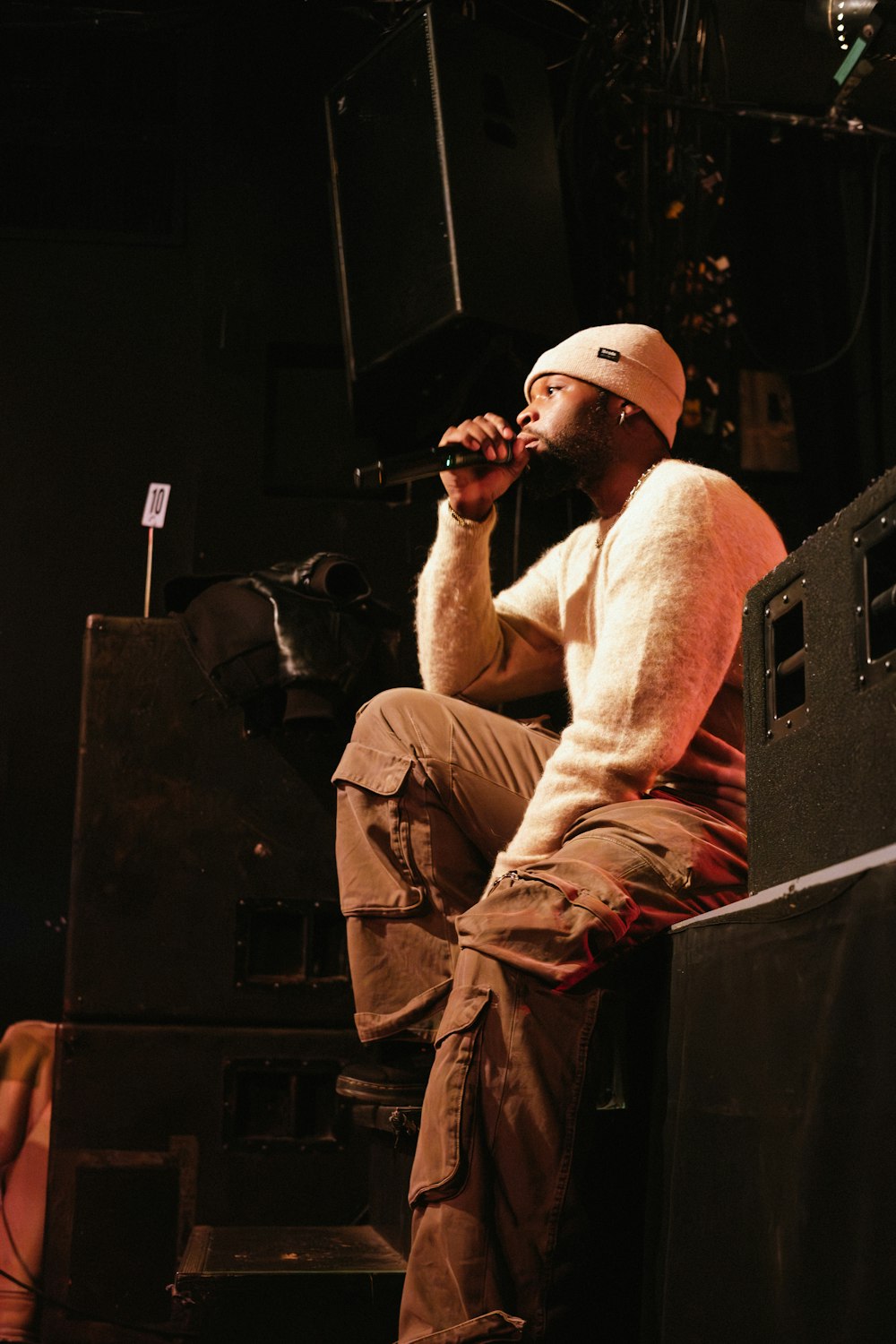 a man sitting on top of a stage with a microphone