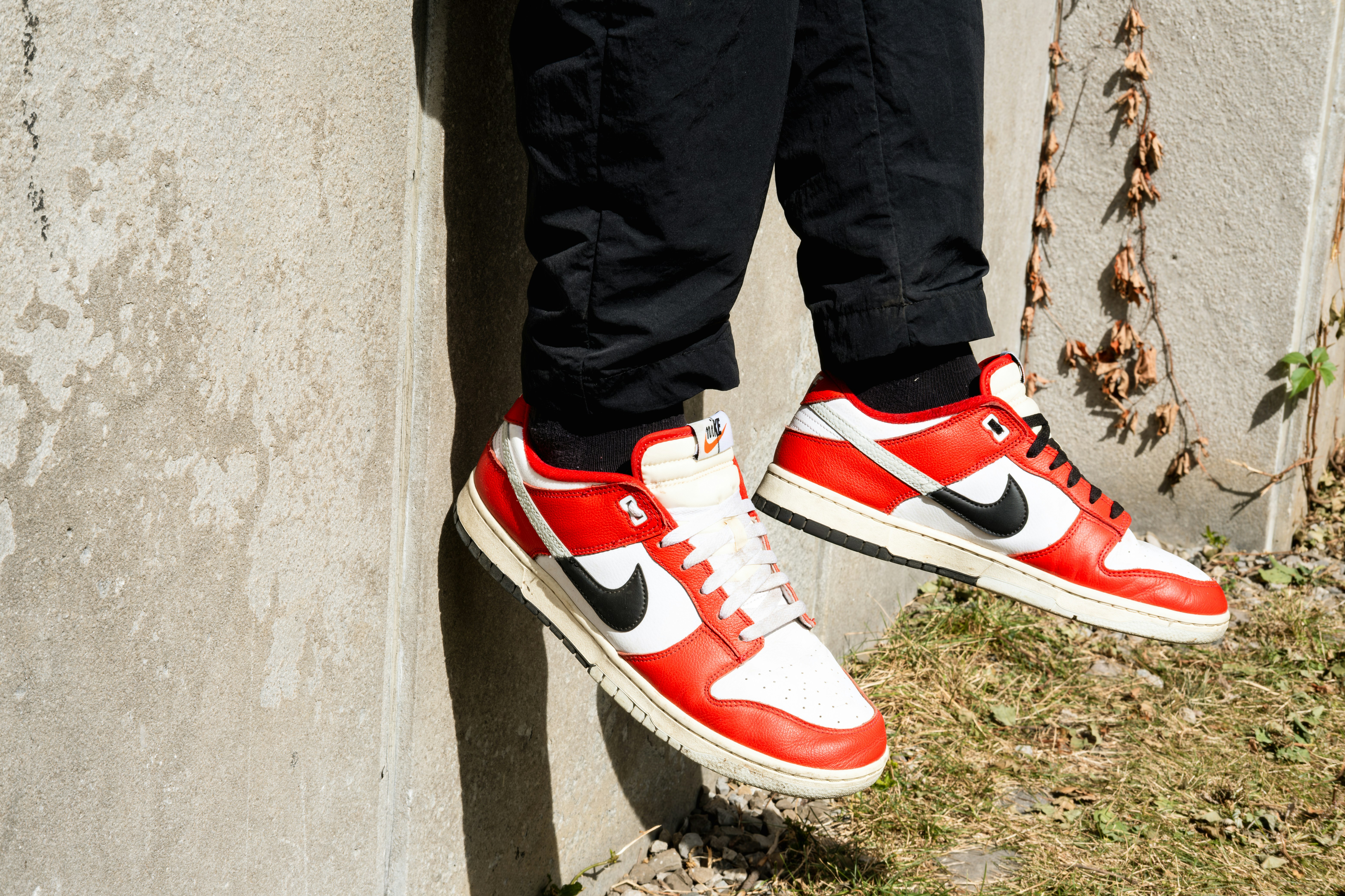 Une paire de baskets rouges et blanches accrochées au flanc d’un mur ...