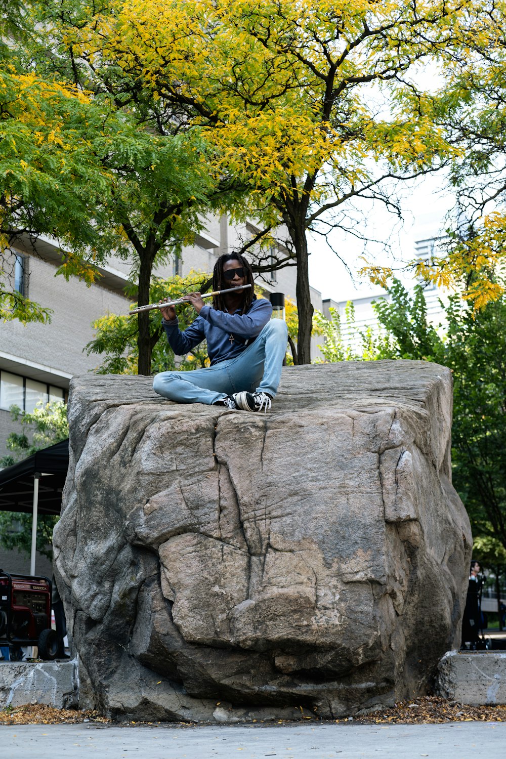 a man sitting on top of a large rock