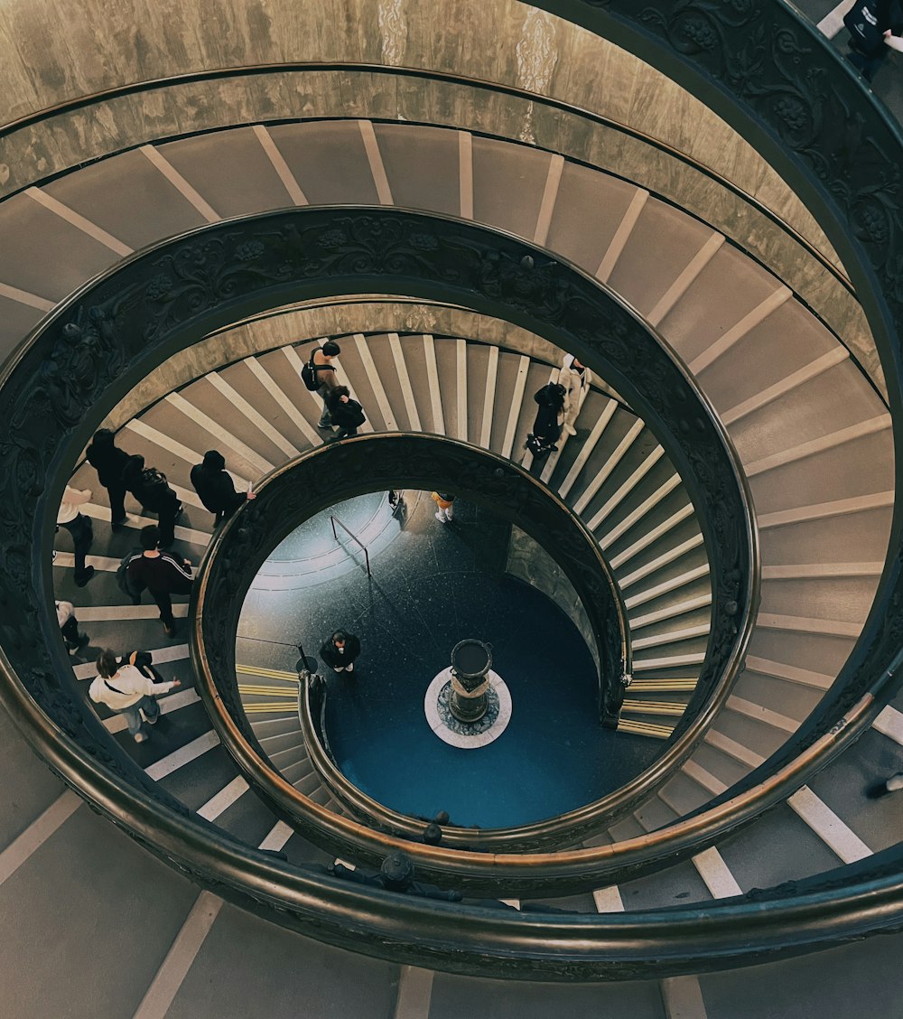 a group of people walking down a spiral staircase