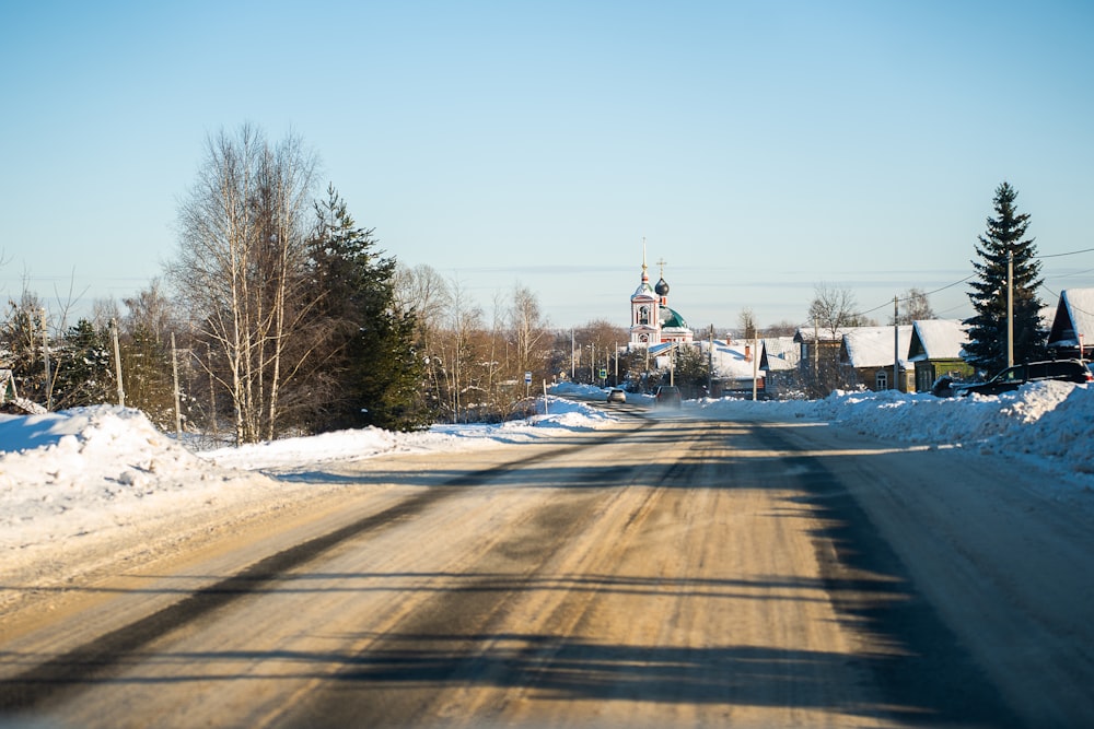 a dirt road with a church in the background