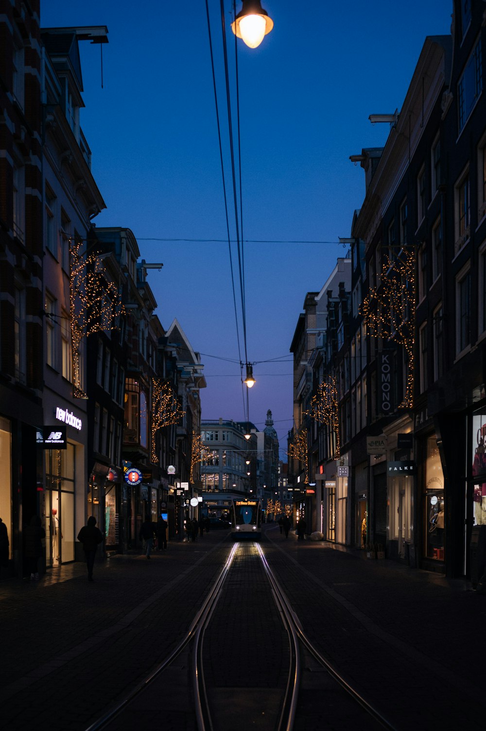 uma rua da cidade à noite com um trem nos trilhos