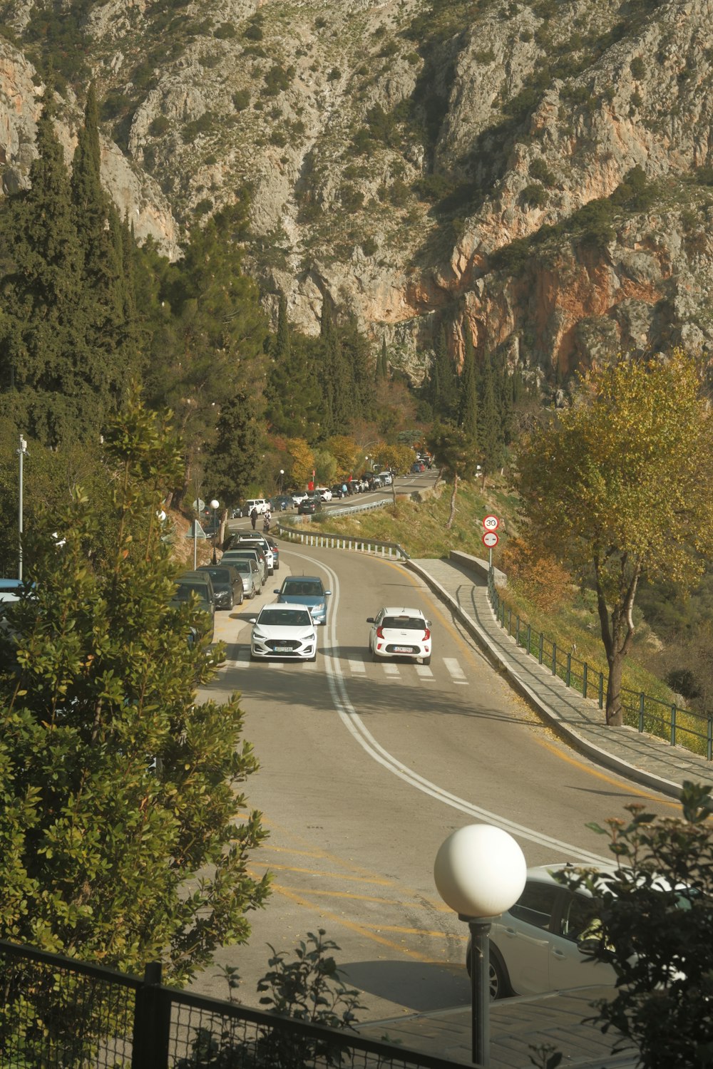 cars are driving down a mountain road