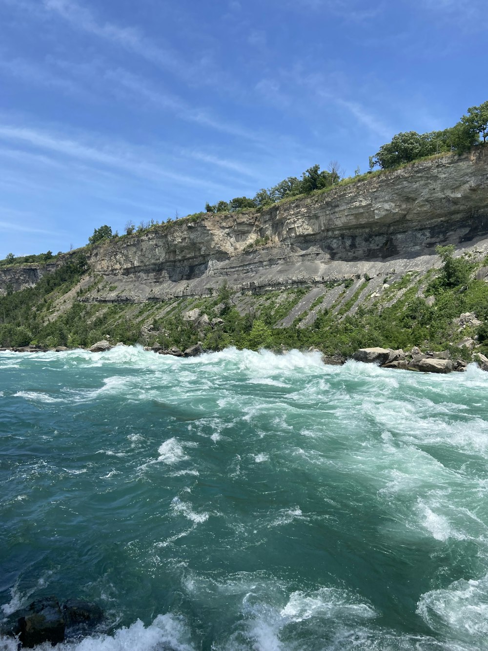 a view of a body of water with a cliff in the background