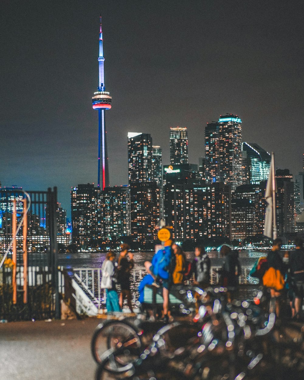 a group of people standing around a city at night