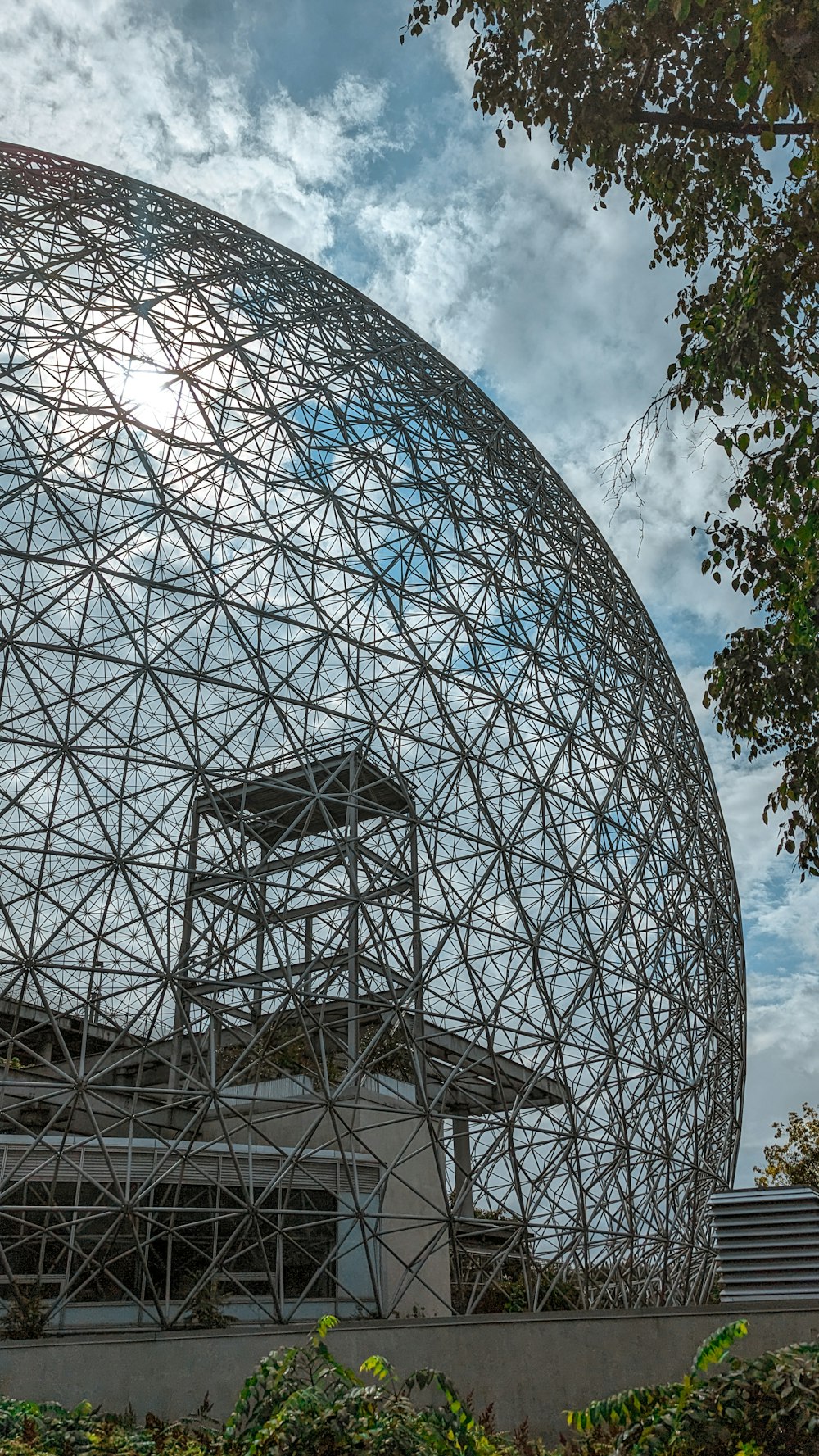 a large metal structure sitting on top of a lush green field