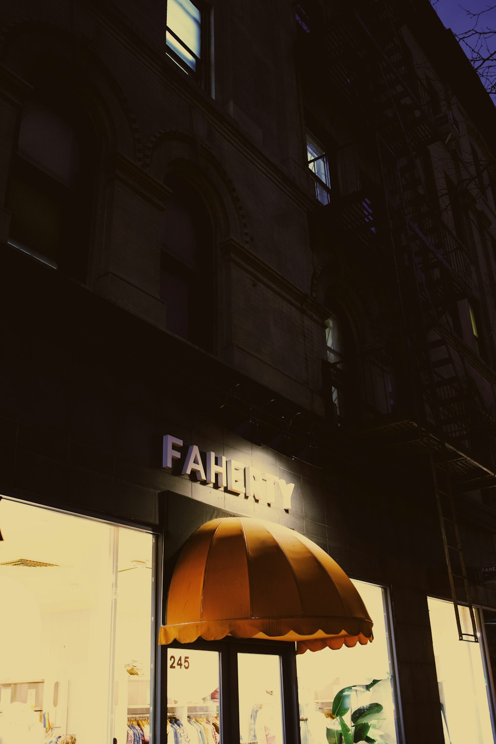 a store front with a yellow umbrella in front of it