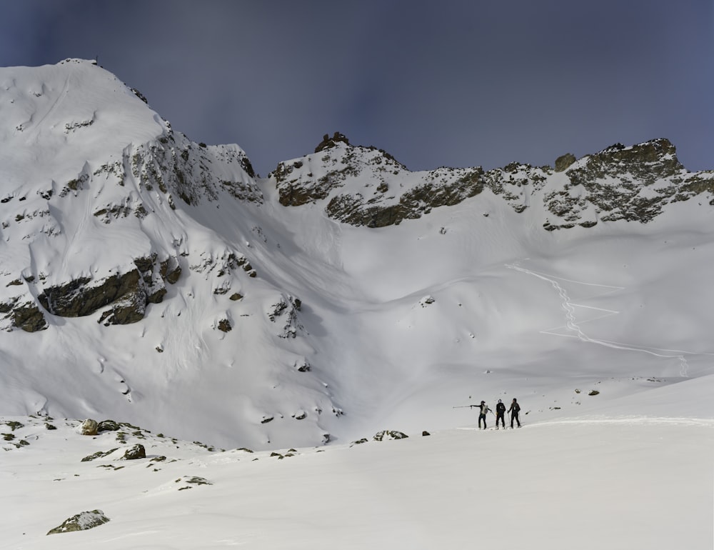 un gruppo di persone in piedi sulla cima di una montagna innevata
