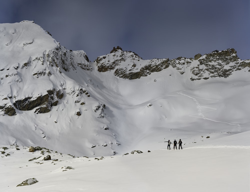 a group of people standing on top of a snow covered mountain