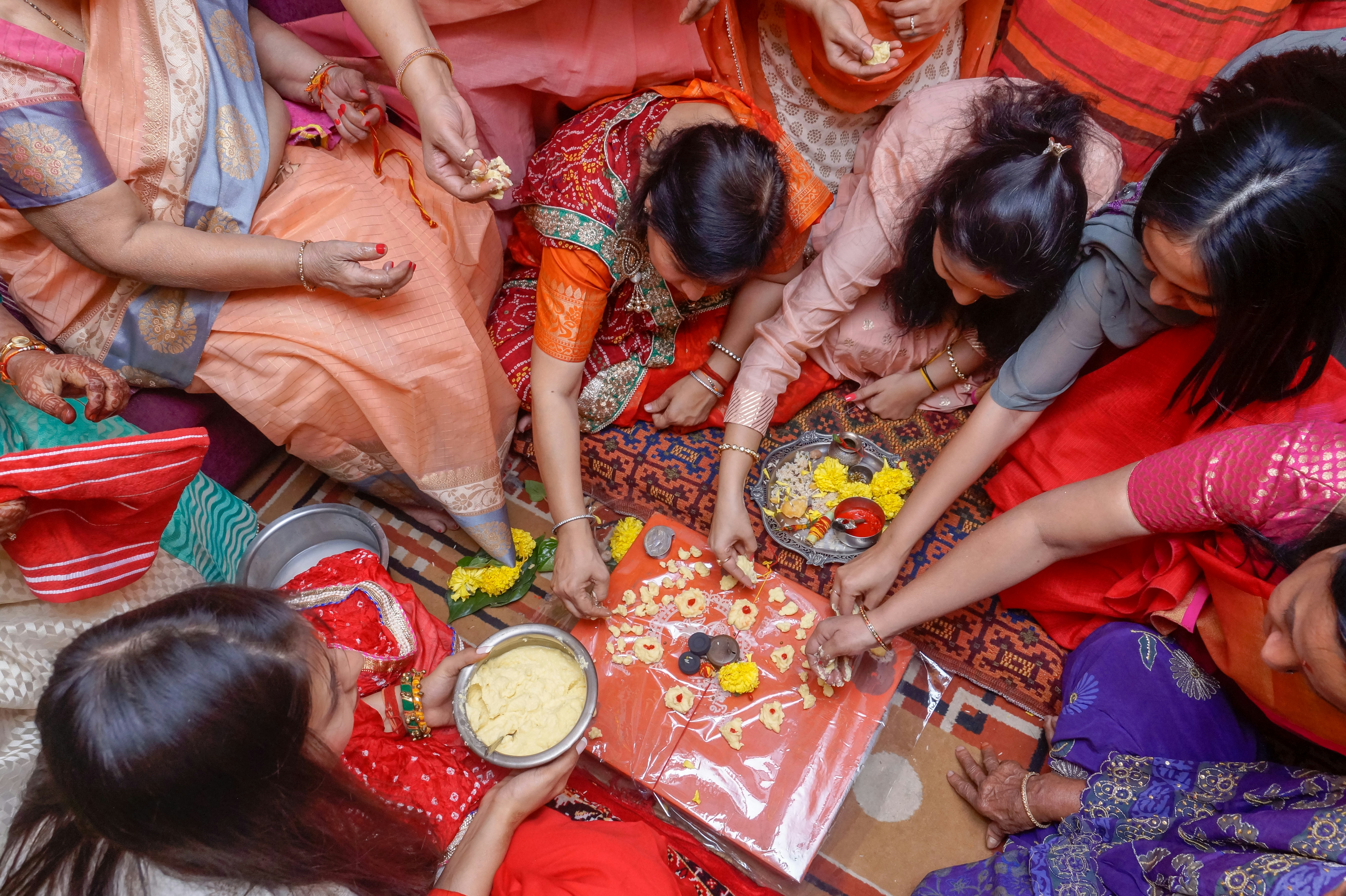 a group of women standing around a table with food on it