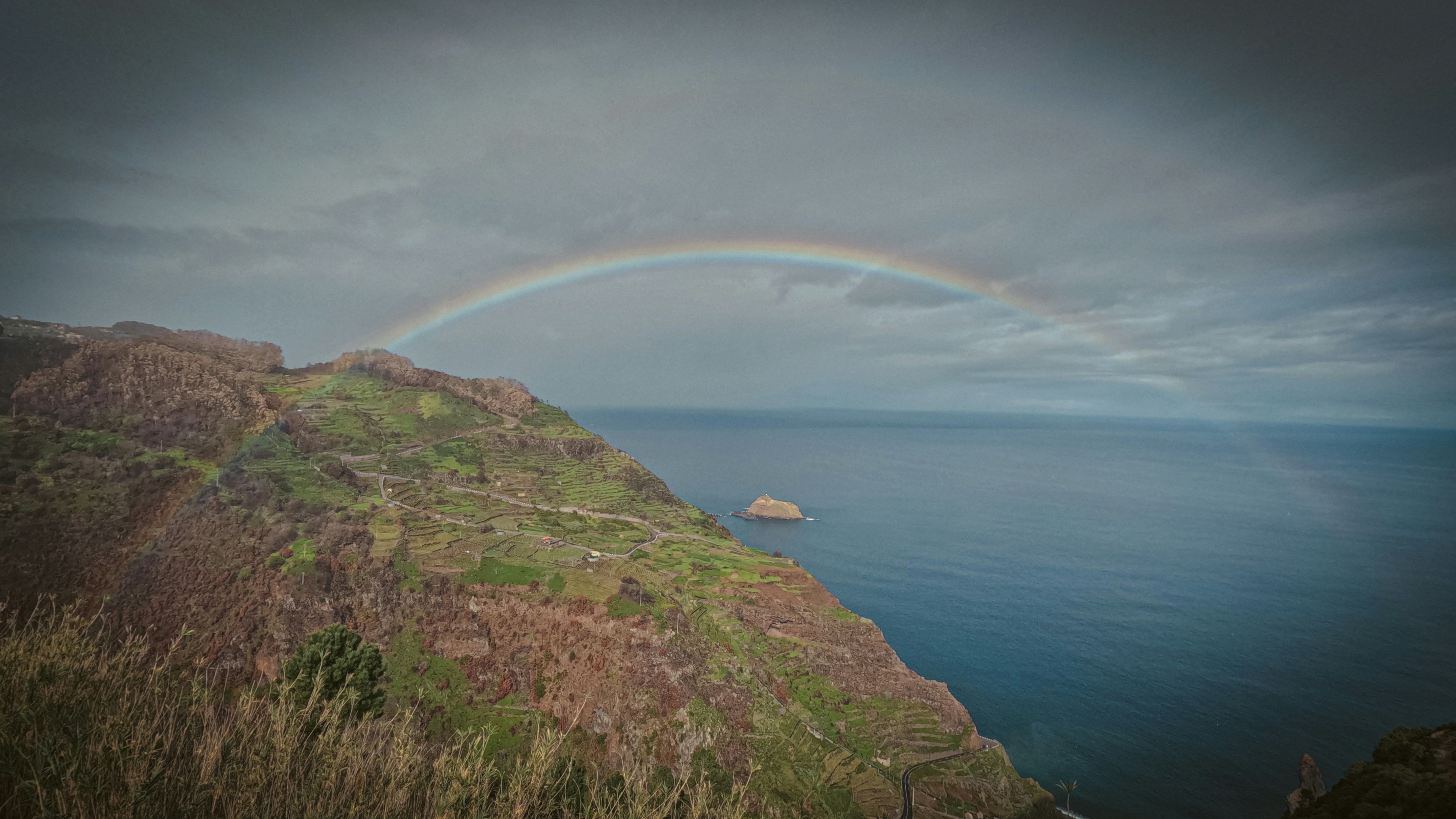 un arcobaleno nel cielo sopra uno specchio d'acqua