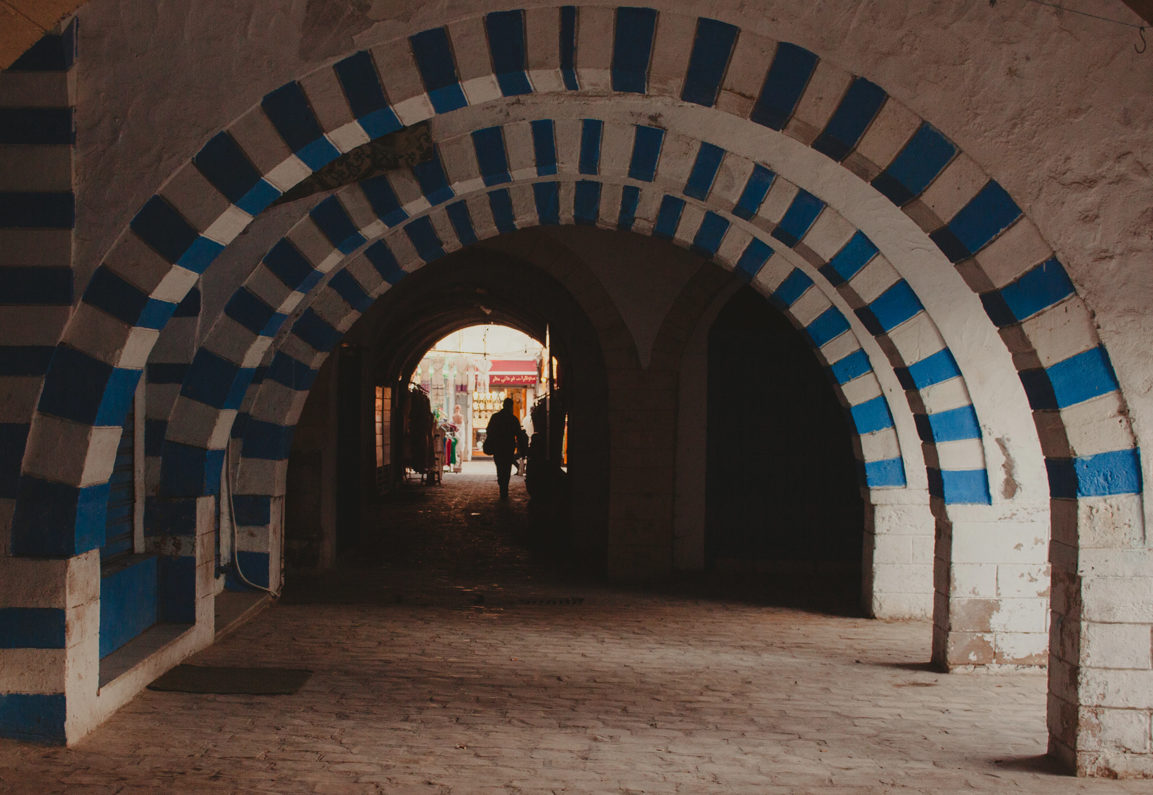 Arched medina passage painted in blue and white stripes