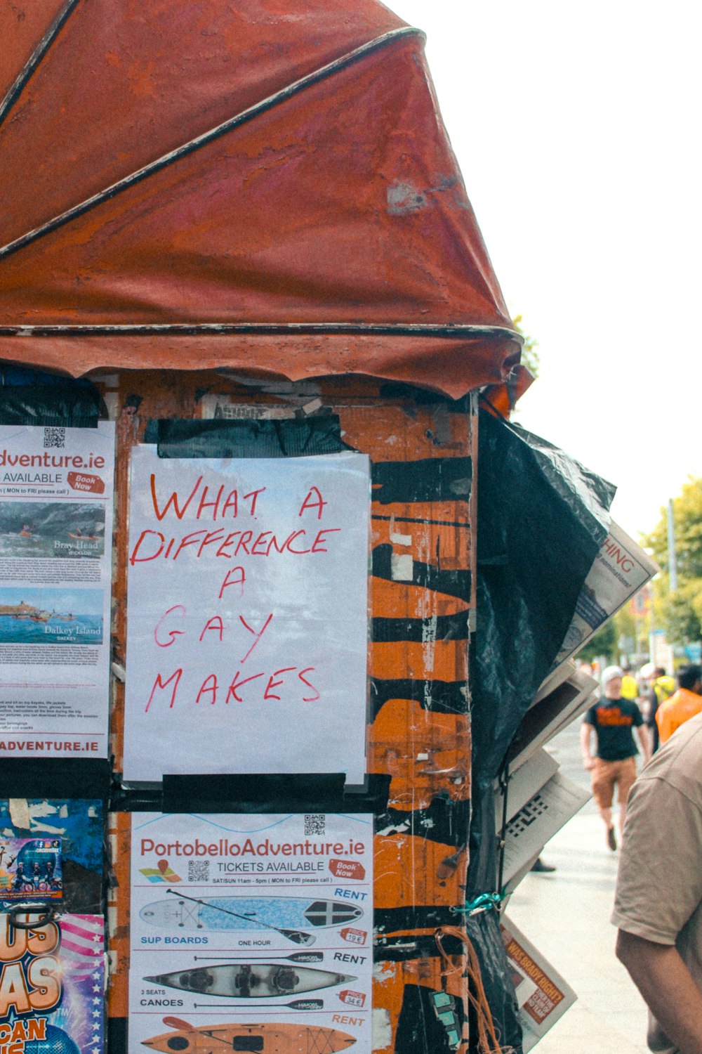 a man standing next to a red tent with a sign on it