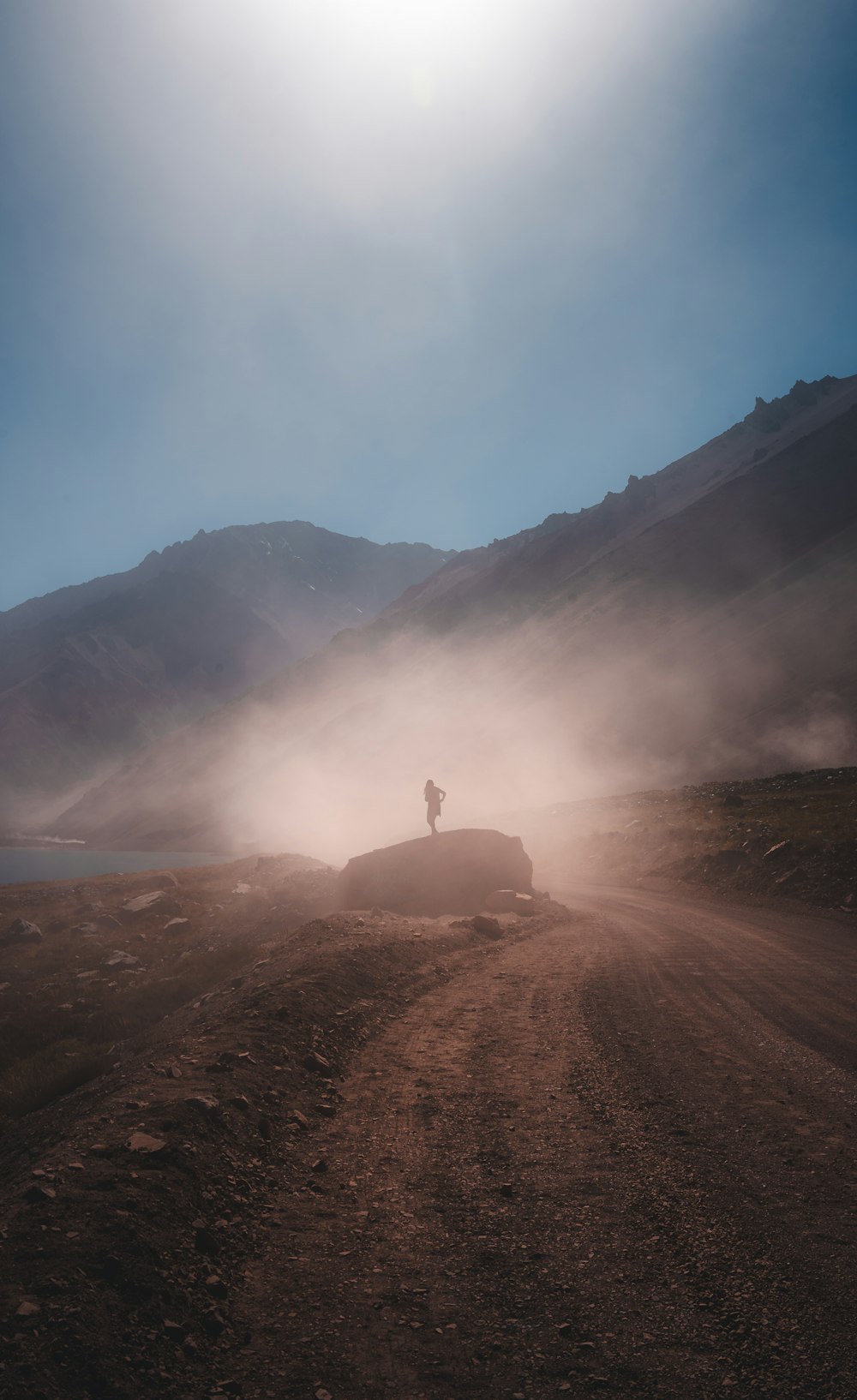 a person standing on top of a dirt road