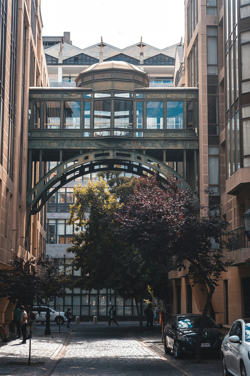 a bridge over a city street with cars parked on the side of it