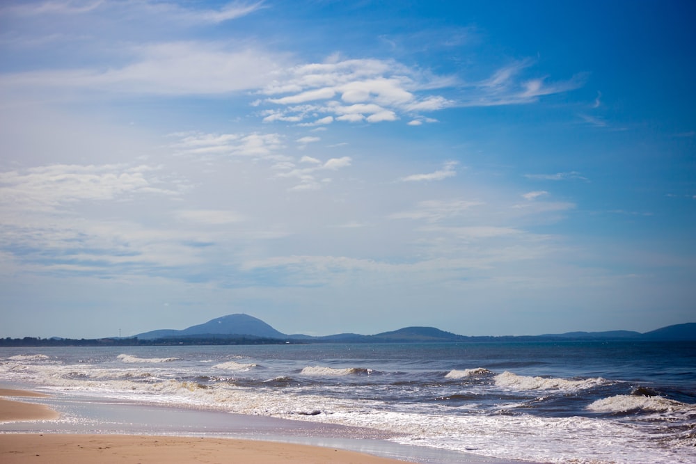 a person walking on the beach with a surfboard