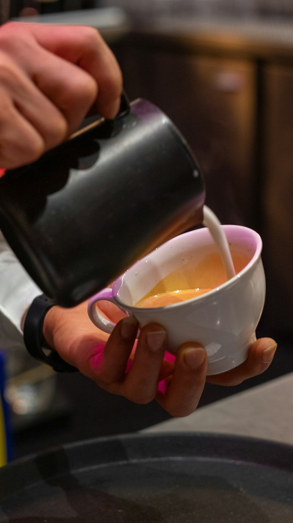 a woman is pouring a cup of coffee