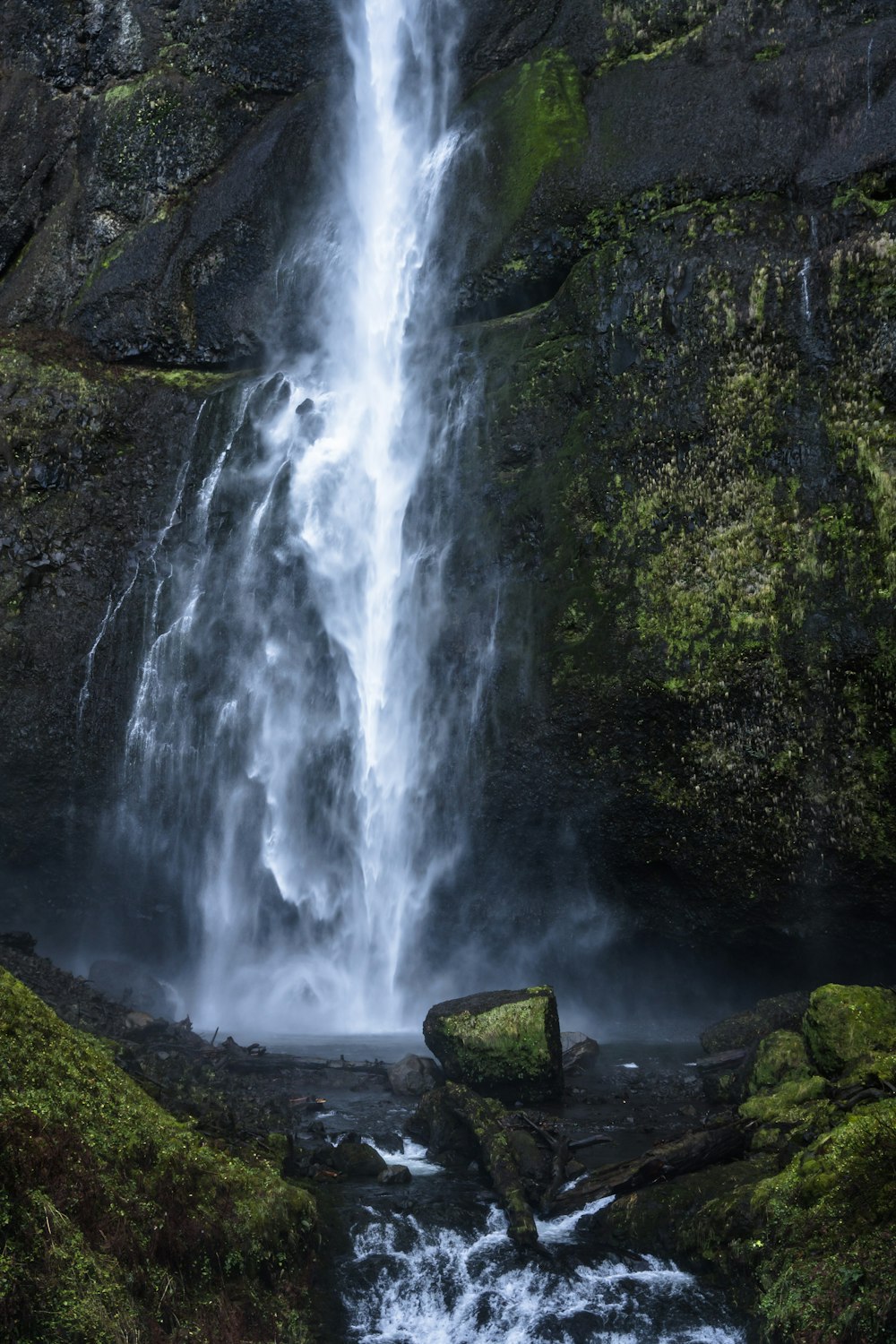 a very tall waterfall in the middle of a forest