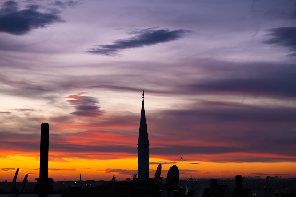 a sunset view of a city with a tower in the distance