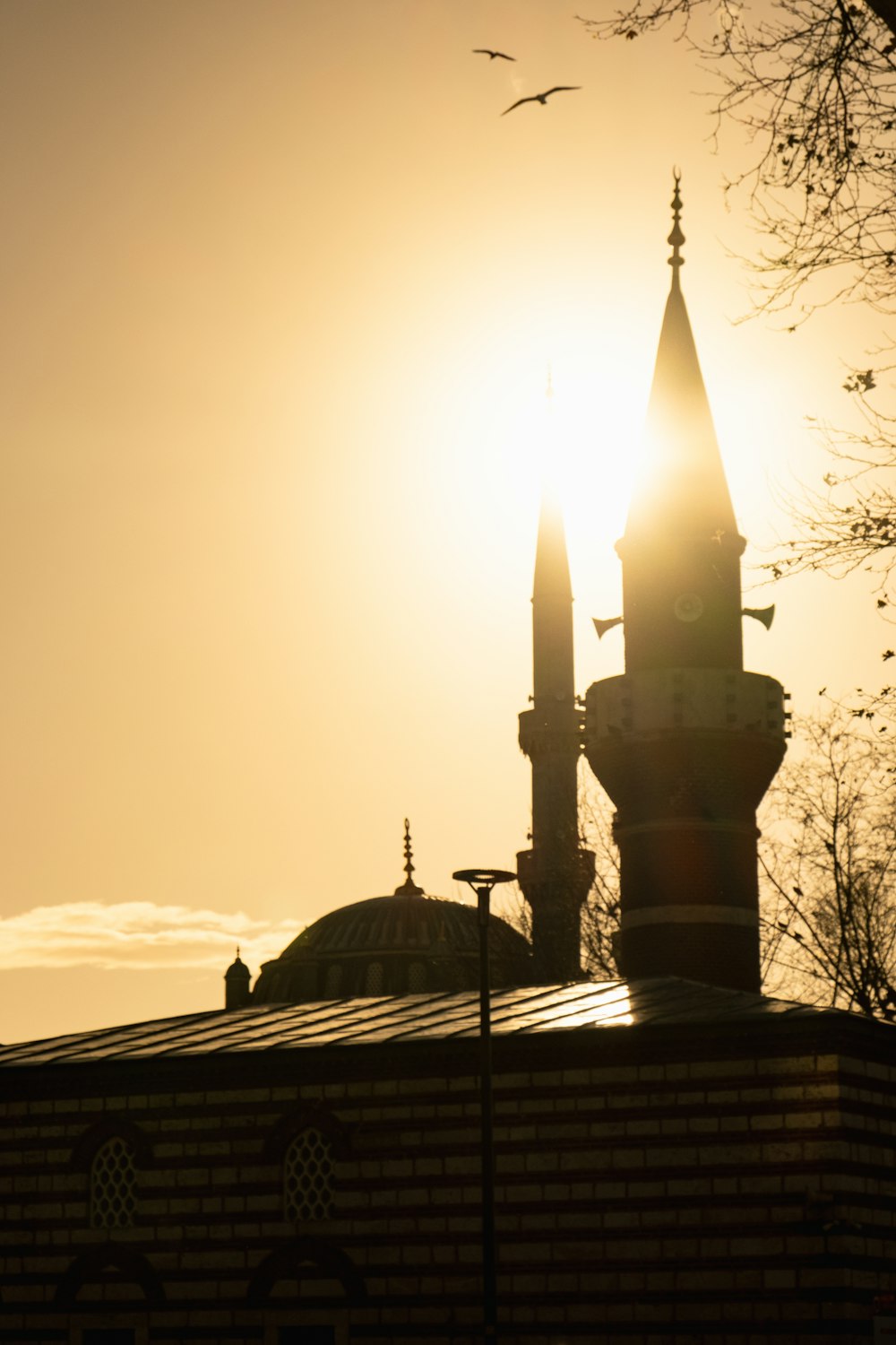 the sun is setting over a building with a clock tower