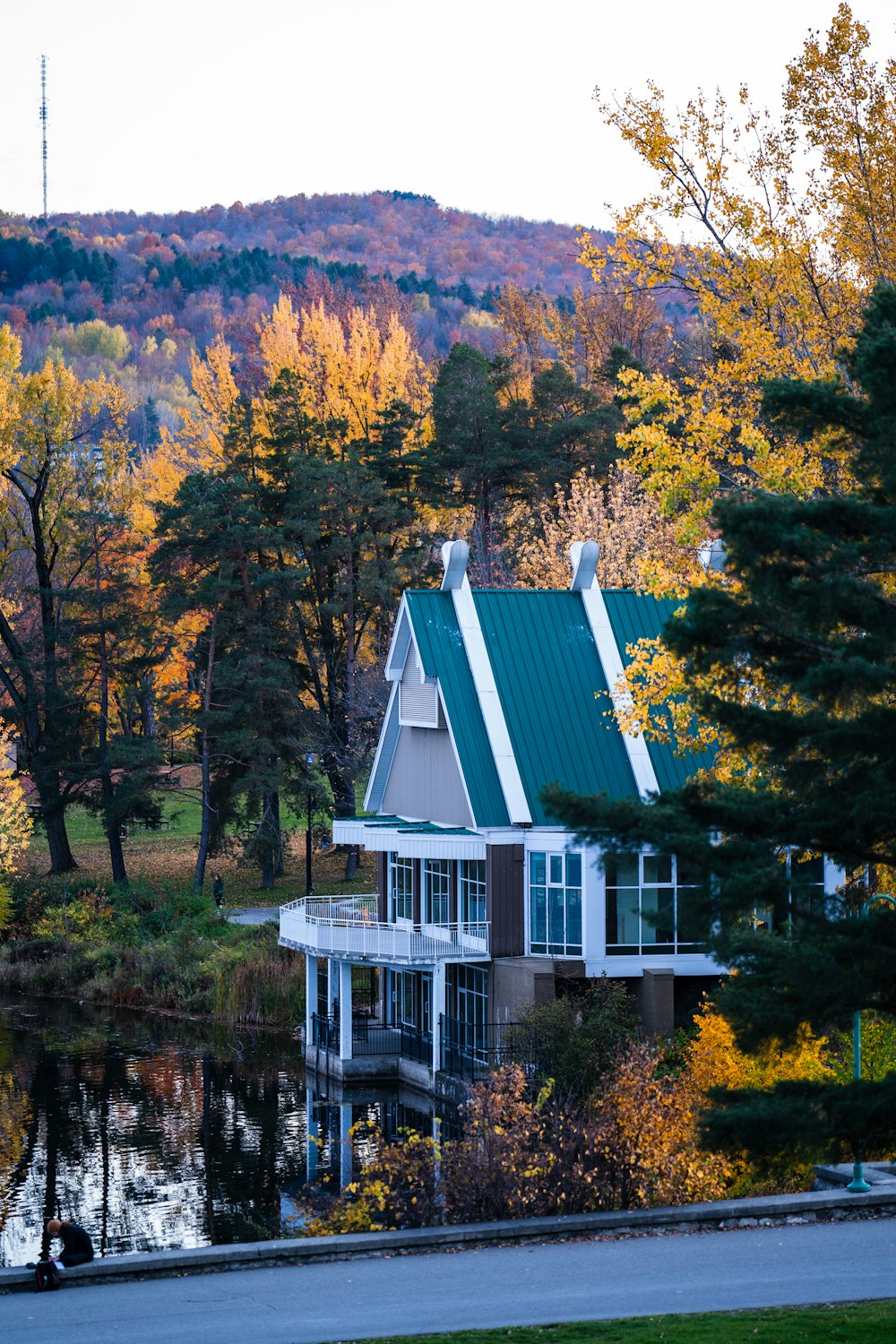 a house sitting next to a lake surrounded by trees