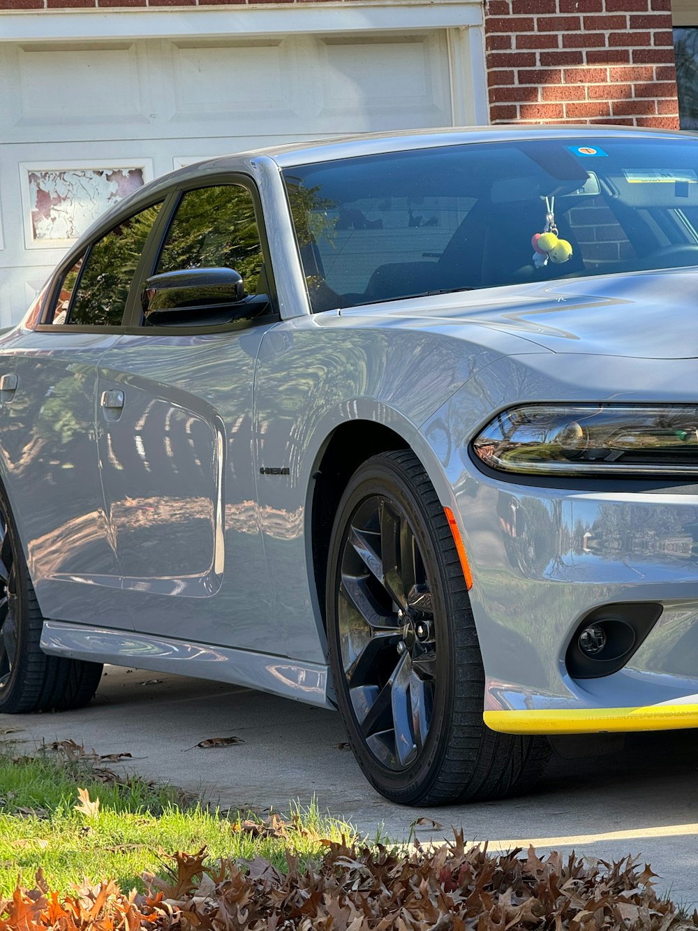 a silver dodge charger parked in front of a house