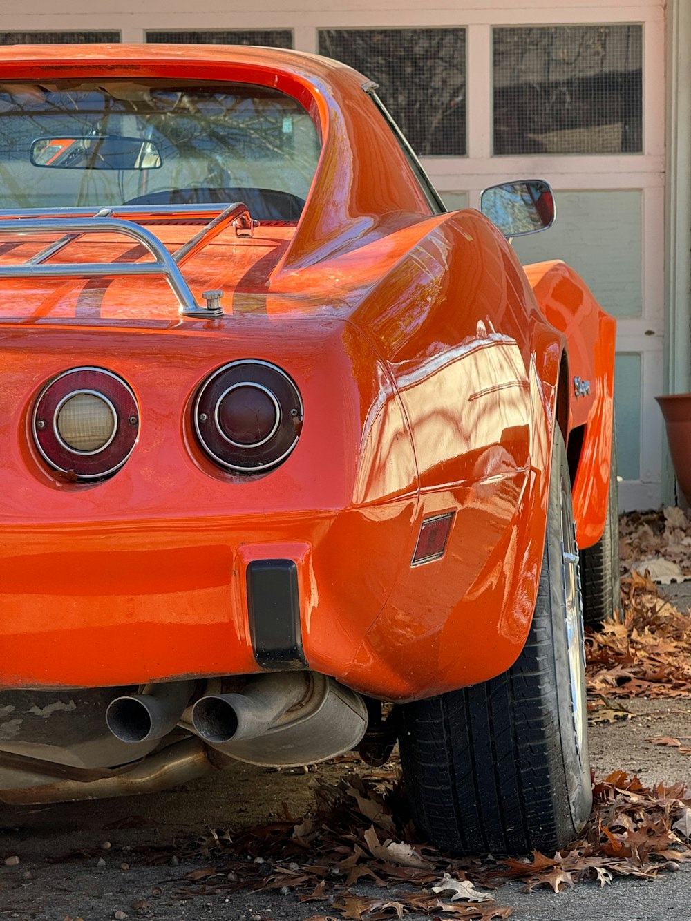 an orange car parked in front of a garage