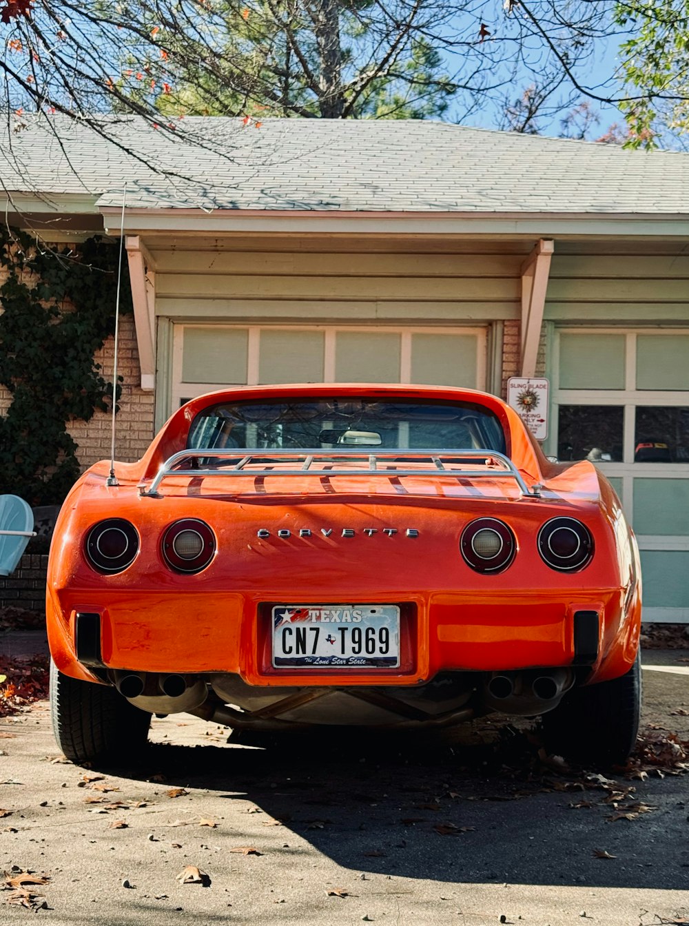 an orange car parked in front of a house