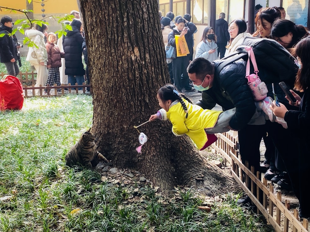 a group of people standing around a tree