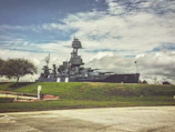 a large battleship sitting on top of a lush green field