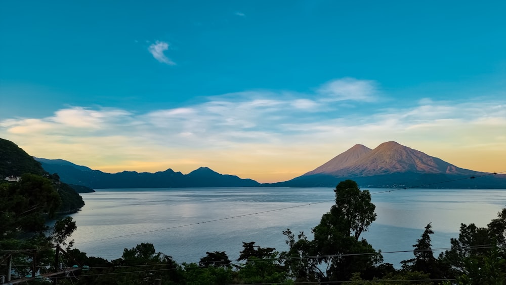 a large body of water with a mountain in the background