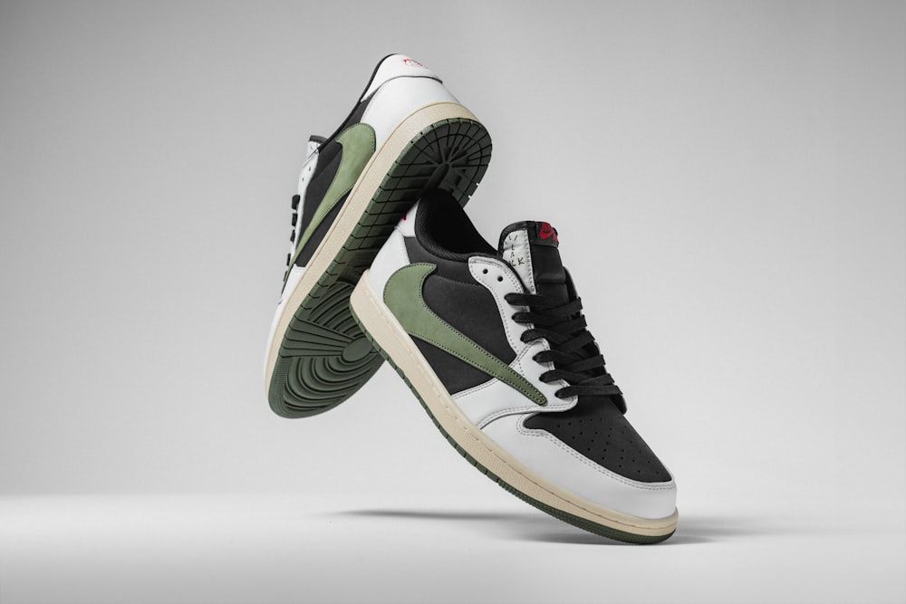 un paio di sneakers bianche e nere con accenti verdi