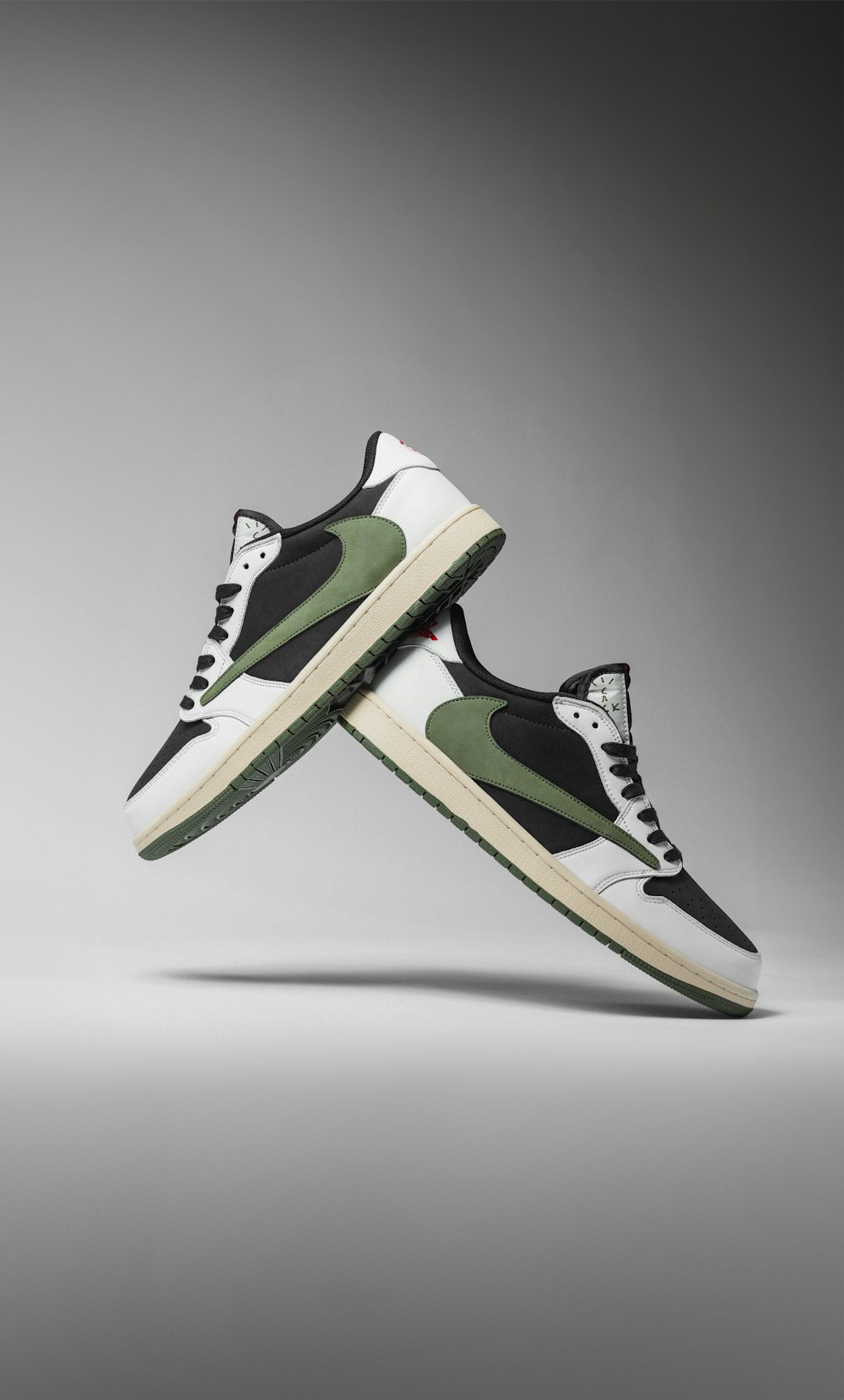 a pair of black and white sneakers with green accents