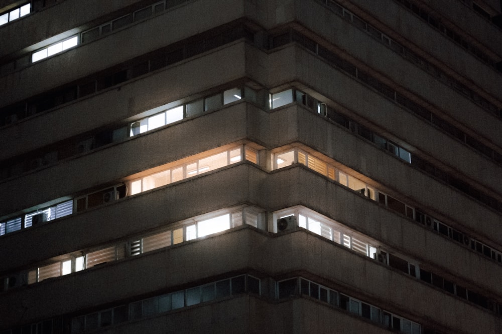 a very tall building with windows lit up at night