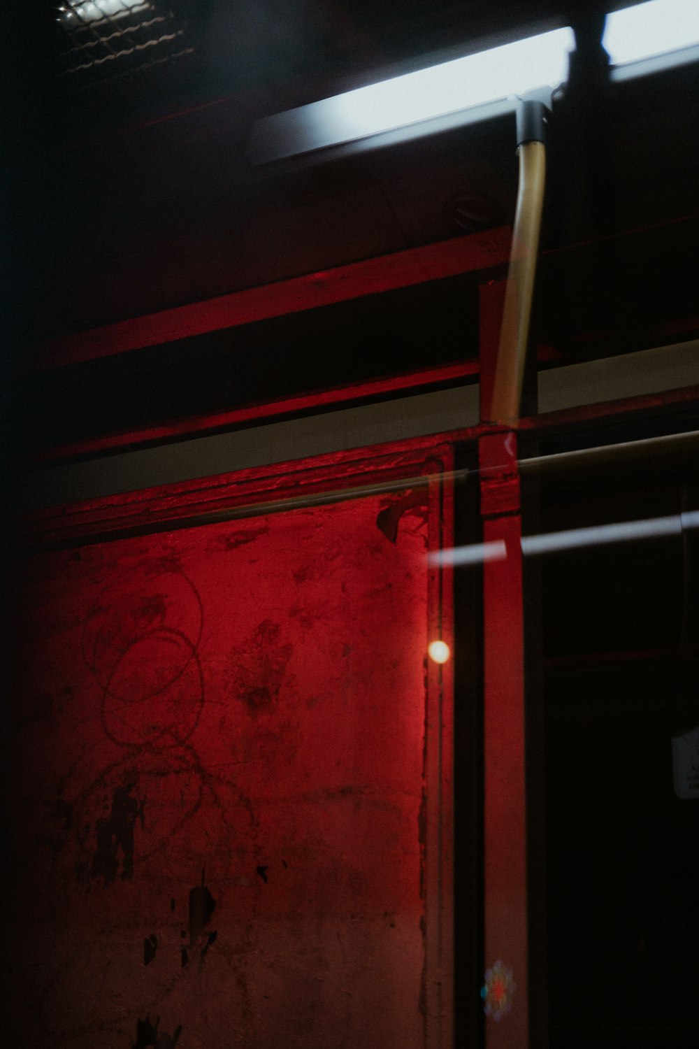 a red light shines on a wall in a dark room