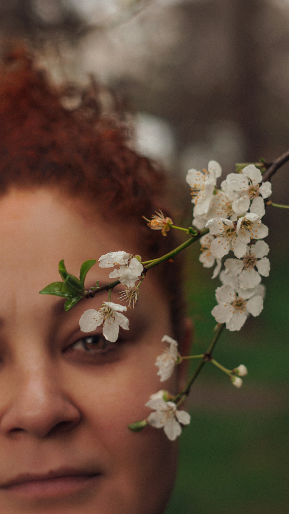 a woman with red hair and a flower on her forehead
