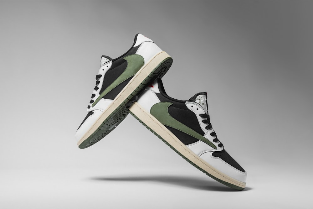 a pair of black and white sneakers with green accents