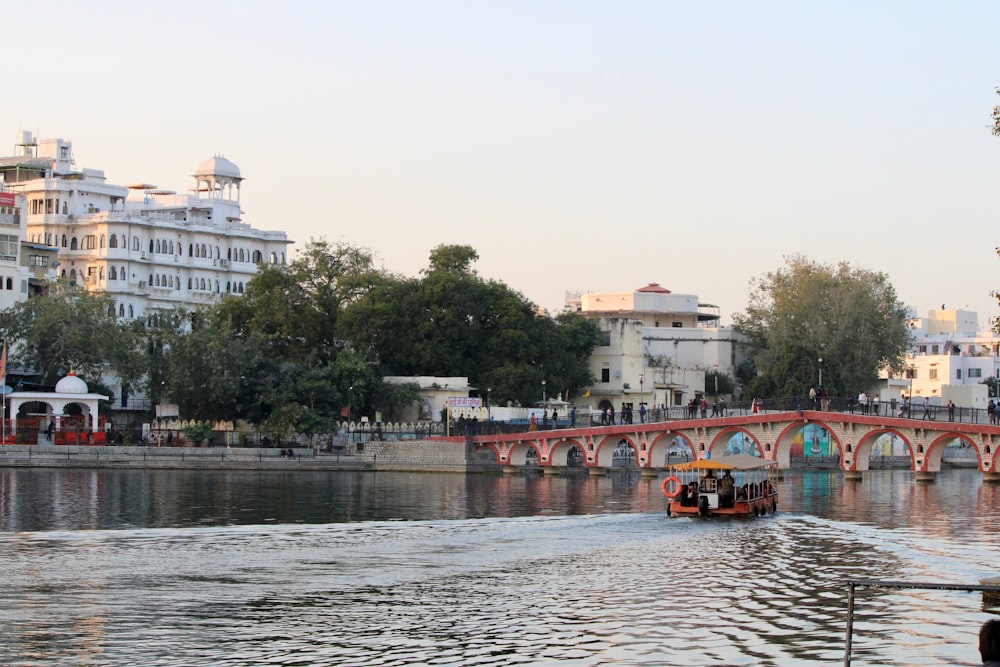 a boat traveling down a river next to a bridge