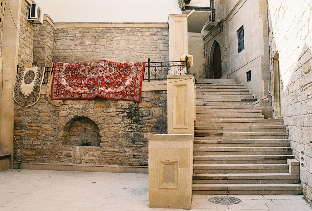 a stone building with a rug hanging on the wall
