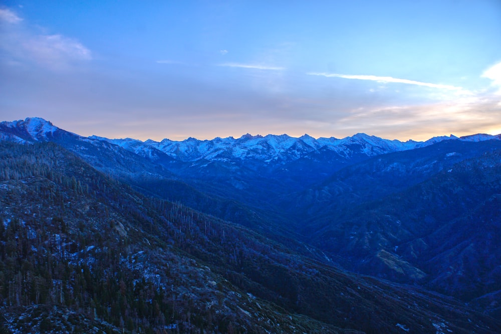 a view of a mountain range with snow capped mountains in the distance