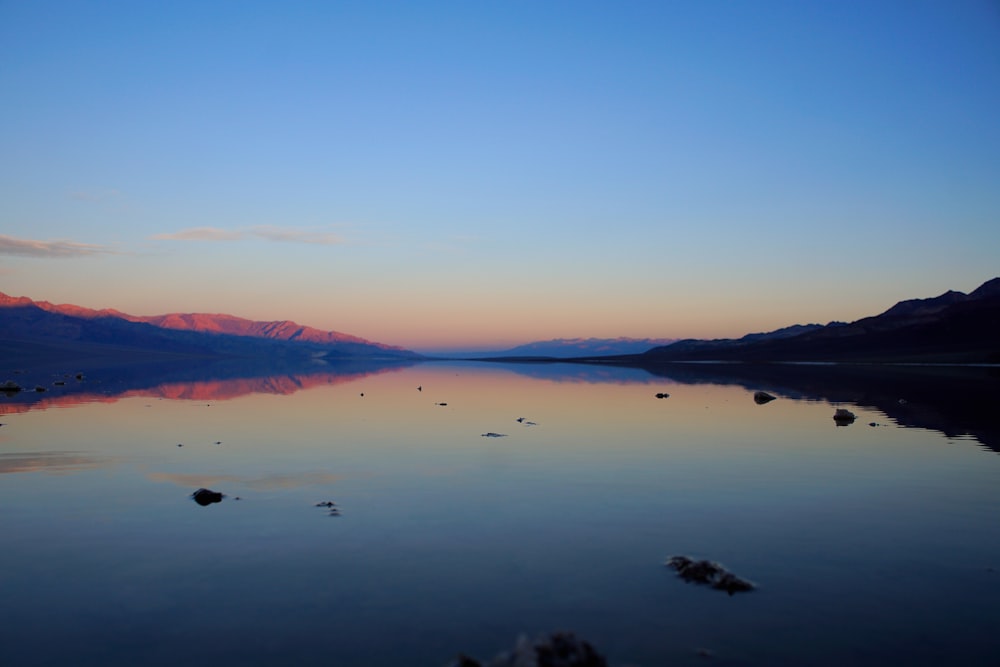 a body of water with mountains in the background