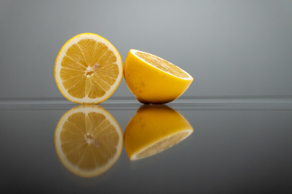 a sliced lemon sitting on top of a reflective surface