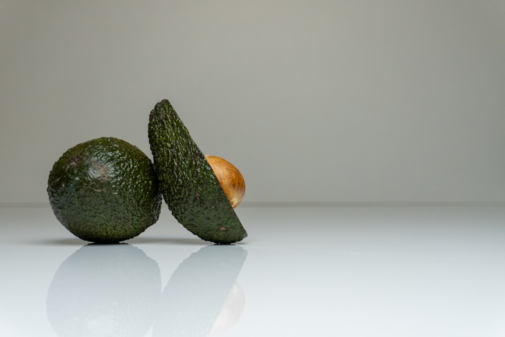 a couple of avocados sitting on top of a table