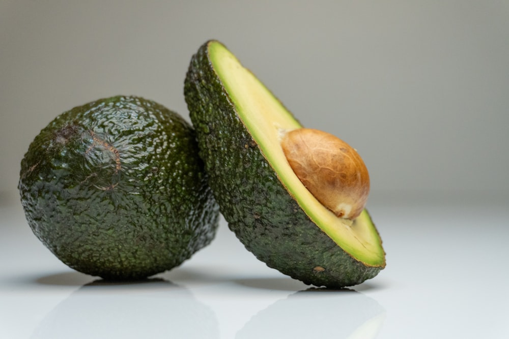 a couple of avocados sitting on top of a table